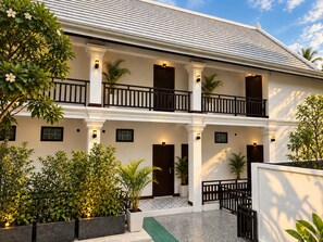 A two-story building with a balcony, columns, and potted plants. - Dawn Boutique Luangprabang Hotel (Luang Prabang)