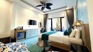 A hotel room with a bed, a desk, a TV, a ceiling fan, and a view of the outside. - Dawn Boutique Luangprabang Hotel (Luang Prabang)