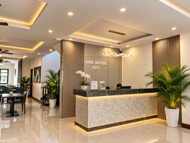 A hotel reception area with a marble counter, a reception desk, and a sign that reads 'DAWN BOUTIQUE HOTEL'.