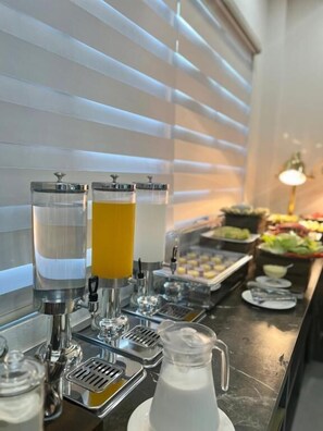A buffet setup with a beverage station featuring a water dispenser and a pitcher of milk. - Dawn Boutique Luangprabang Hotel (Luang Prabang)