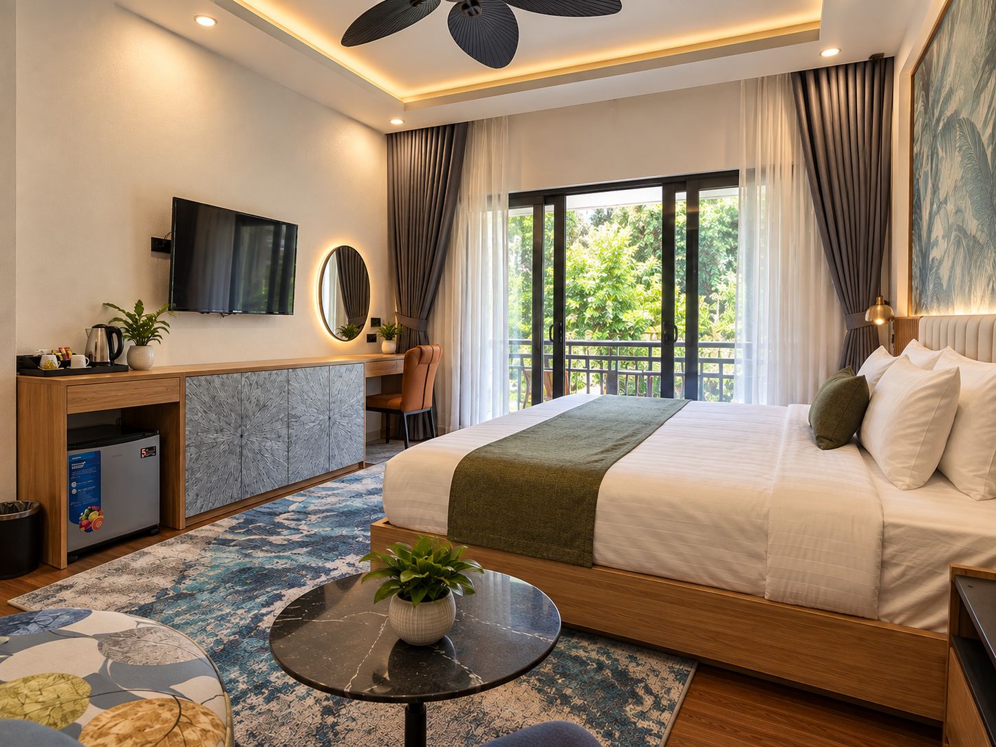 Habitación de hotel moderna con cama, escritorio, televisión y balcón con vista a zonas verdes.