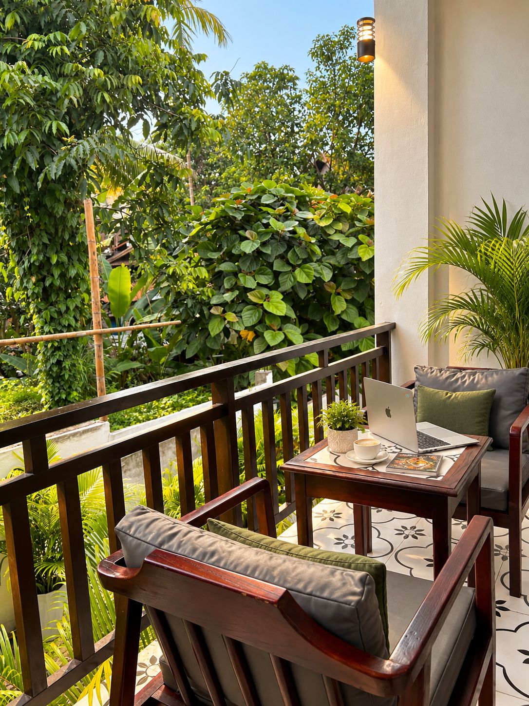 Un balcon avec une balustrade en bois, une table avec un ordinateur portable, une chaise avec des coussins et une plante en pot.