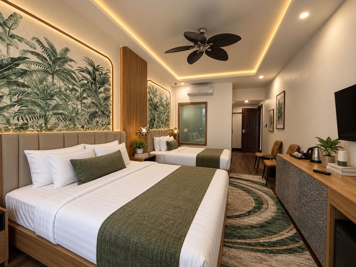 A hotel room with a large bed, a desk, a chair, a ceiling fan, and a wall-mounted TV.