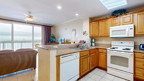 A modern kitchen with wooden cabinets, a built-in oven, and a dishwasher. - Lovely lakefront condo with lake view, kitchen, pool & hot tub near attractions (Orlando)