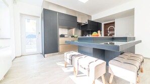 Una cucina moderna con mobili scuri, un'isola centrale e un'ampia finestra.