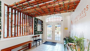 A restaurant interior with a wooden pergola, seating area, and a sign for 'VINEYARDS BAR & GRILLE'. - Resort condo close to theme parks with on-site pool, bar, restaurant, & gym (Davenport)