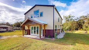A two-story house with a covered porch and a garage. - Riverfront home with internet, washer and dryer, and perfect for kayaking (Sebring)
