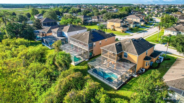 A residential area with houses, green lawns, and a clear sky. - Gorgeous home near Disney with private pool, pool spa, on-site gym, tennis, AC (Davenport)