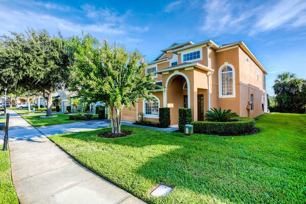 A two-story house with a well-maintained lawn, a sidewalk, and a clear sky. - 5BR/3BA Davenport home with private pool (Davenport)