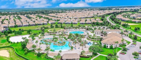Una zona residencial con una piscina grande, varios edificios y céspedes bien cuidados.