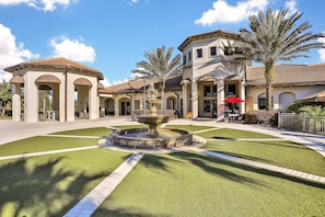 A courtyard with a central fountain, palm trees, and a building with arched walkways. - Spacious townhouse with resort amenities, private heated pool and W/D (Davenport)