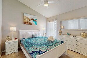 A bedroom with a bed, nightstands, a dresser, a ceiling fan, and a painting on the wall. - Charming home with pool, enclosed yard, central AC, & washer/dryer (Davenport)
