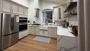 A modern kitchen with stainless steel appliances, white cabinetry, and a marble backsplash. - Charming 1-bedroom house in excellent Prescott location with AC (Prescott)
