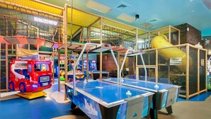 An indoor play area with a blue table tennis table, a red fire truck, and a yellow slide. - Sunny Oasis | Townhouse in Davenport with resort amenities, near Disney (Davenport)
