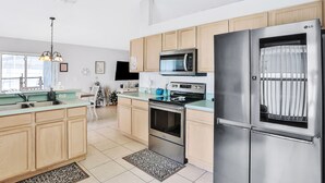 Una cocina moderna con electrodomésticos de acero inoxidable, armarios de madera y un amplio ventanal.