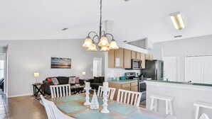 Una cocina moderna con armarios blancos, un microondas y un refrigerador de acero inoxidable.