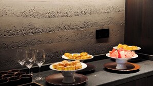 A buffet setup with various food items and glasses on a counter. - ChangSha Super Awake Century Hotel (Changsha)