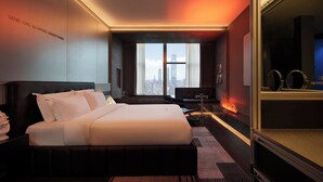 A hotel room with a large bed, a desk, and a view of the city skyline through large windows. - ChangSha Super Awake Century Hotel (Changsha)