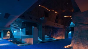 A modern interior with a staircase, stone walls, and illuminated signage. - ChangSha Super Awake Century Hotel (Changsha)
