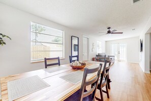 A dining area with a wooden table, chairs, and a bowl of decorative balls. - Single-story house with private pool, alfresco dining, & lanai - dog-friendly (Kissimmee)