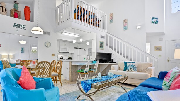 A spacious living area with a dining set, a sofa, a coffee table, and a kitchen in the background. - Breezy townhouse with a pool, hot tub, patio, central AC, and washer/dryer (Kissimmee)