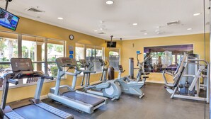 Une salle de sport équipée de tapis de course, de vélos elliptiques et d'appareils de musculation.