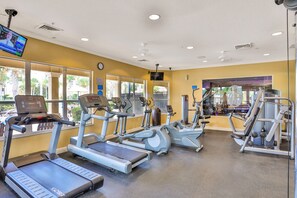 Ein Fitnessstudio mit Laufbändern, Crosstrainern und Gewichten.