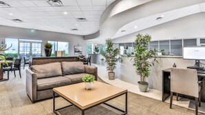 A modern lobby with a sofa, coffee table, and potted plants. - Two-story, dog-friendly gem near theme parks with pool, central AC & on-site gym (Kissimmee)