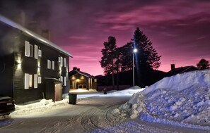 A snow-covered street with a house on the left and a snow pile on the right. - Pet friendly apartment in Kåbdalis with WiFi (Kåbdalis)