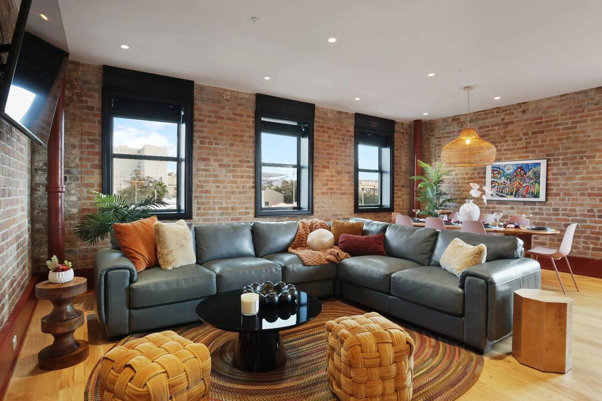 A modern living room with a sectional sofa, a round coffee table, and a dining area with a table and chairs.