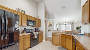 Una cocina moderna con armarios de madera, electrodomésticos de acero inoxidable y una isla central.