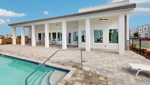 A modern building with a swimming pool, covered outdoor seating, and large windows. - Modern Townhouse with Private Pool Near Disney & Top Attractions (Davenport)