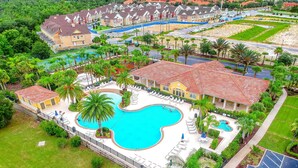 Um resort com uma grande piscina, várias villas para hóspedes e paisagismo exuberante.