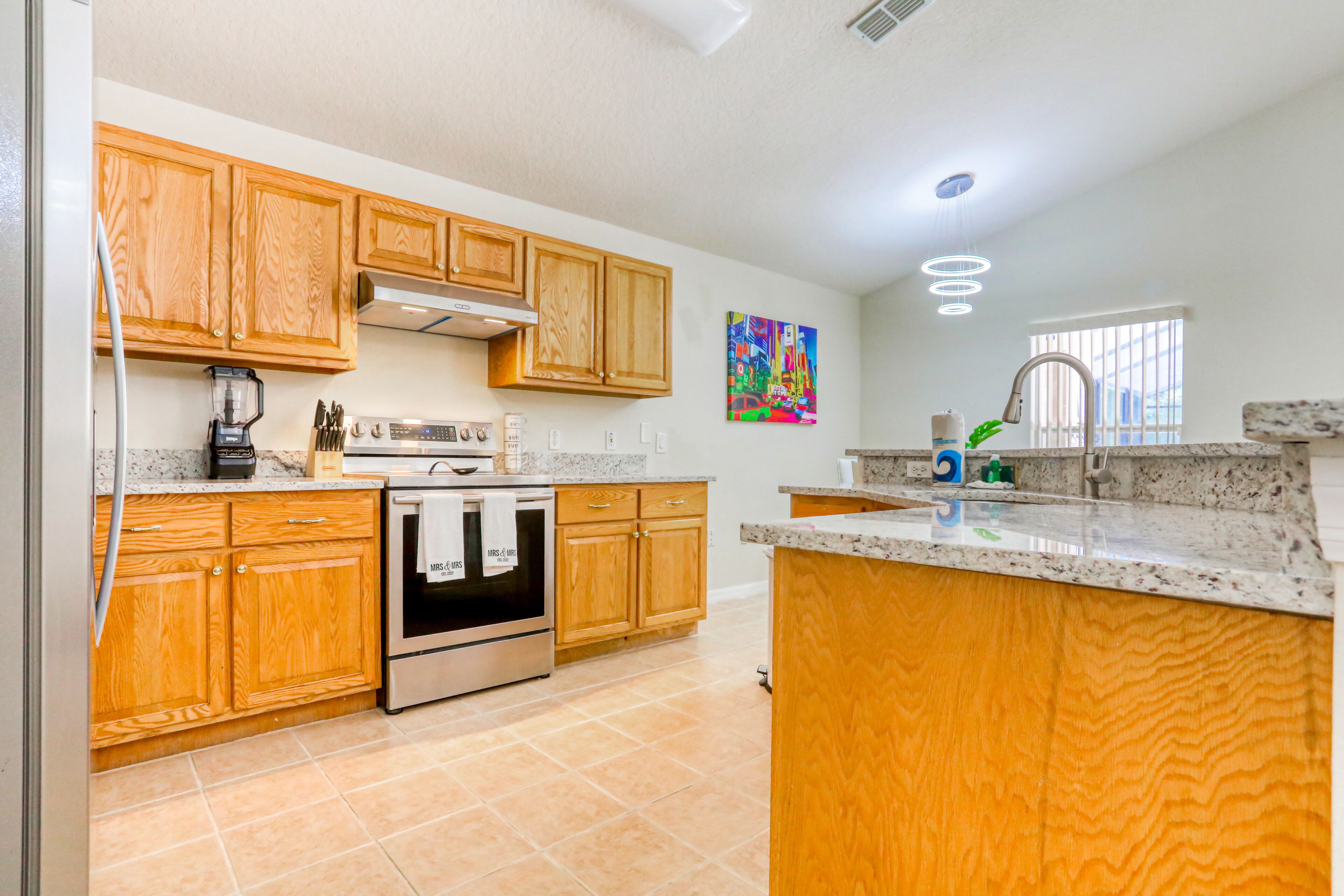A kitchen with wooden cabinets, a stainless steel oven, and a granite countertop.