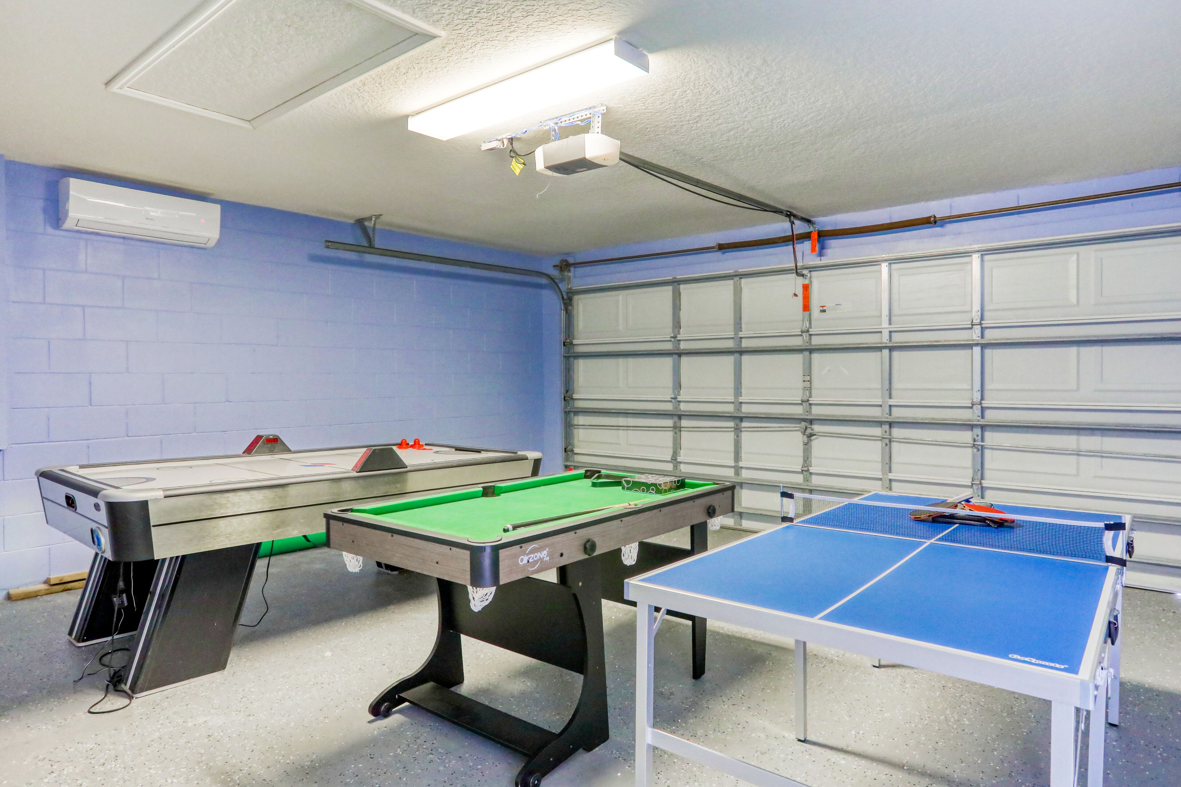 Une salle de billard équipée d’une table de billard américain, d’une table de snooker et d’une table de ping-pong.
