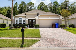 A residential house with a garage, a driveway, and a mailbox. - 4BR Kissimmee Pool Home in Gated Cumbrian Lakes (Kissimmee)