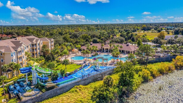 Un resort con un amplio espacio de piscina, toboganes acuáticos y vistas del paisaje circundante.