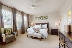 Une chambre à coucher comprenant un lit, une chaise, une table de chevet et une commode.