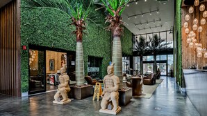 A lobby with a green wall, seating areas, and a statue. - Modern villa with patio, grill, central AC, WiFi, shared pool, tennis, & gym (Kissimmee)