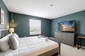 A bedroom with a bed, a dresser, a TV, and a window with blinds. - Cozy townhouse with private screened patio & community pool – near theme parks (Davenport)
