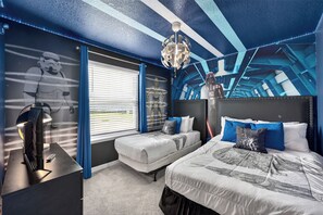 A bedroom with two beds, a ceiling light fixture, and Star Wars-themed wall art. - Exquisite home with pool, lanai, game room, central AC, & washer/dryer (Davenport)