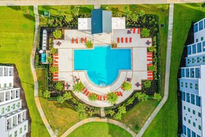 An aerial view of a hotel with a central swimming pool, surrounded by lounge areas and greenery. - Fourth Floor Penthouse with Shared Pools and Hot Tub, Fast WiFi, & Central AC (Kissimmee)