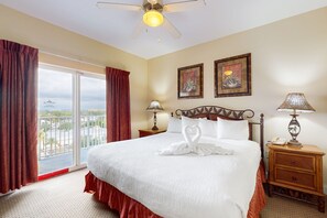A hotel room with a large bed, two bedside tables, a ceiling fan, and a balcony with curtains. - Blue Heron Beach Resort 2BR/2BA Orlando Near Disney, Pool (Orlando)