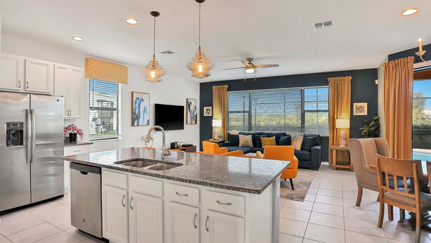 A modern kitchen with a central island, stainless steel appliances, and pendant lighting. - Modern Family Home - Private Pool, Lanai, WiFi, Central AC & Washer-Dryer (Davenport)