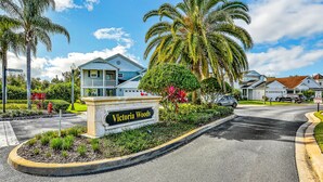 A residential area with a sign reading "Victoria Woods" and houses with a blue roof. - Modern Family Home - Private Pool, Lanai, WiFi, Central AC & Washer-Dryer (Davenport)
