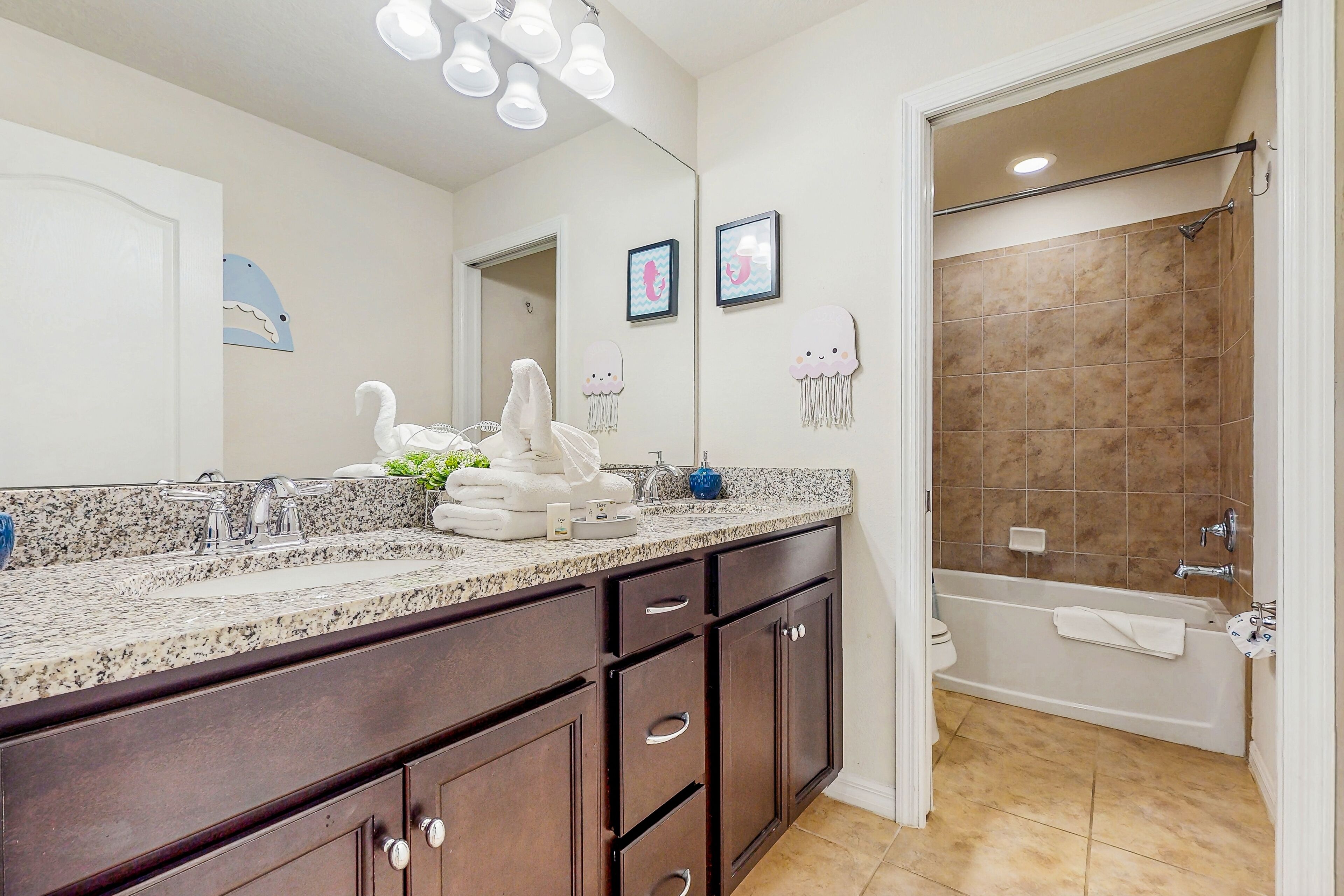 Une salle de bain avec un grand miroir, un lavabo avec un robinet, une baignoire et un espace douche.