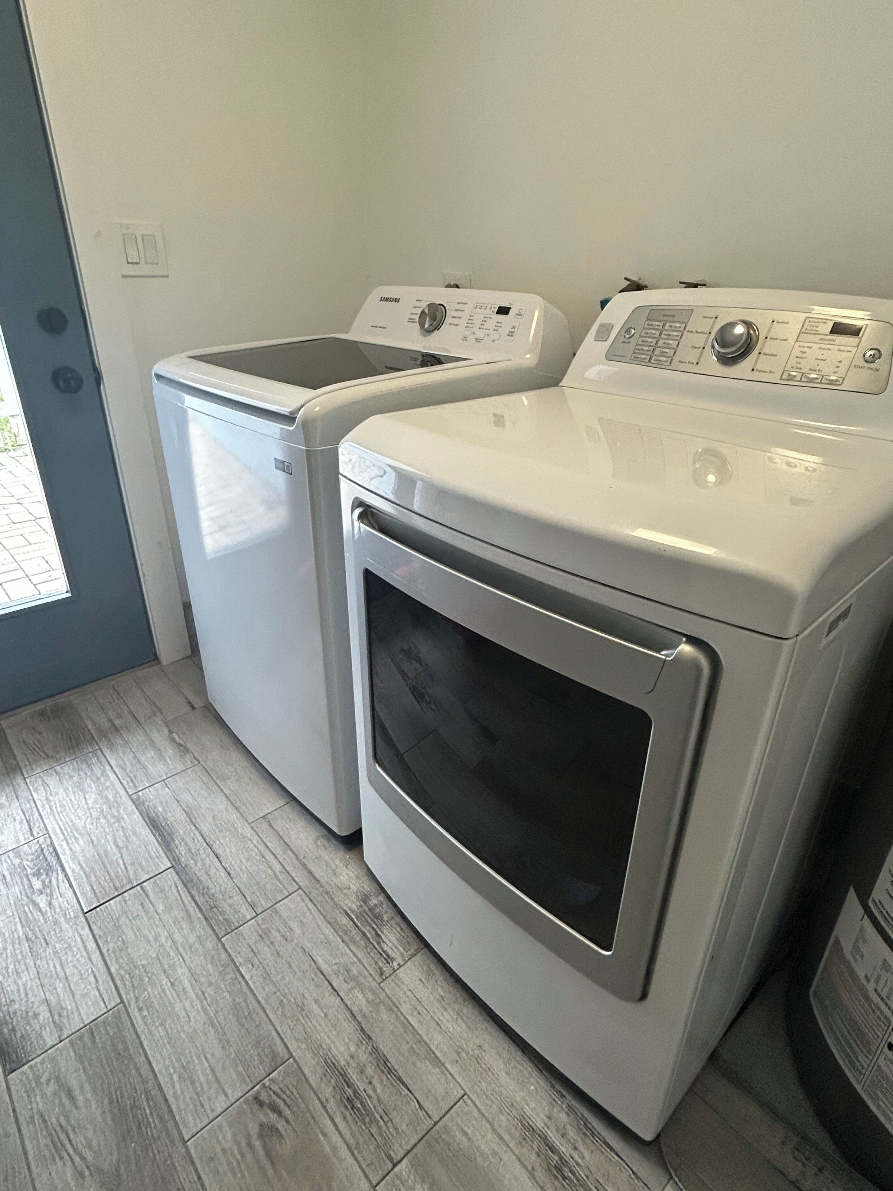 A laundry area with two front-loading washing machines and a dryer.