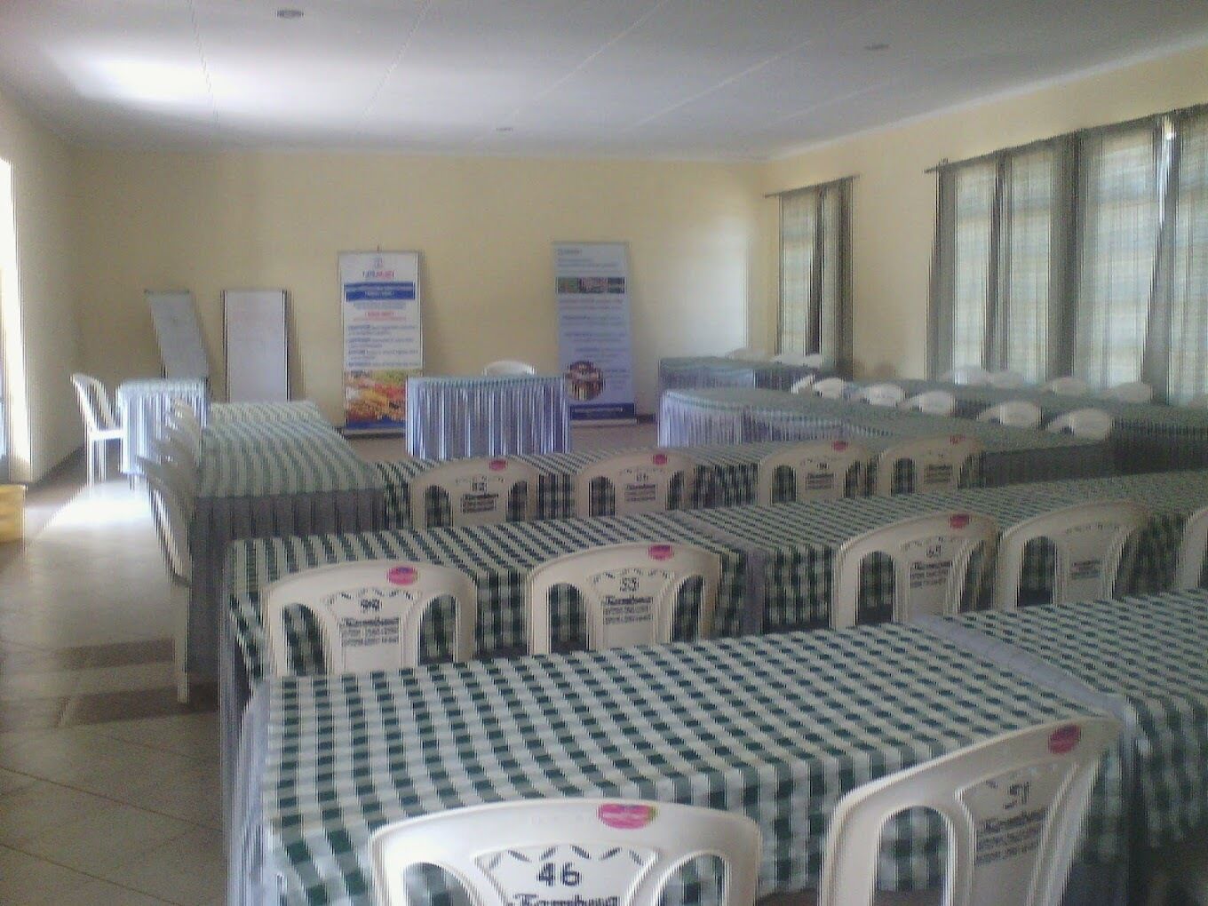 A conference room with tables and chairs, a whiteboard, and informational posters on the walls.