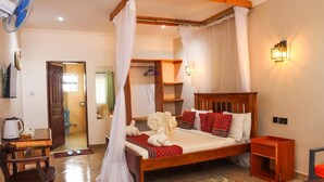 Un dormitorio con cama de madera, ropa de cama blanca, una mesita de noche, una lámpara de pared y una silla.