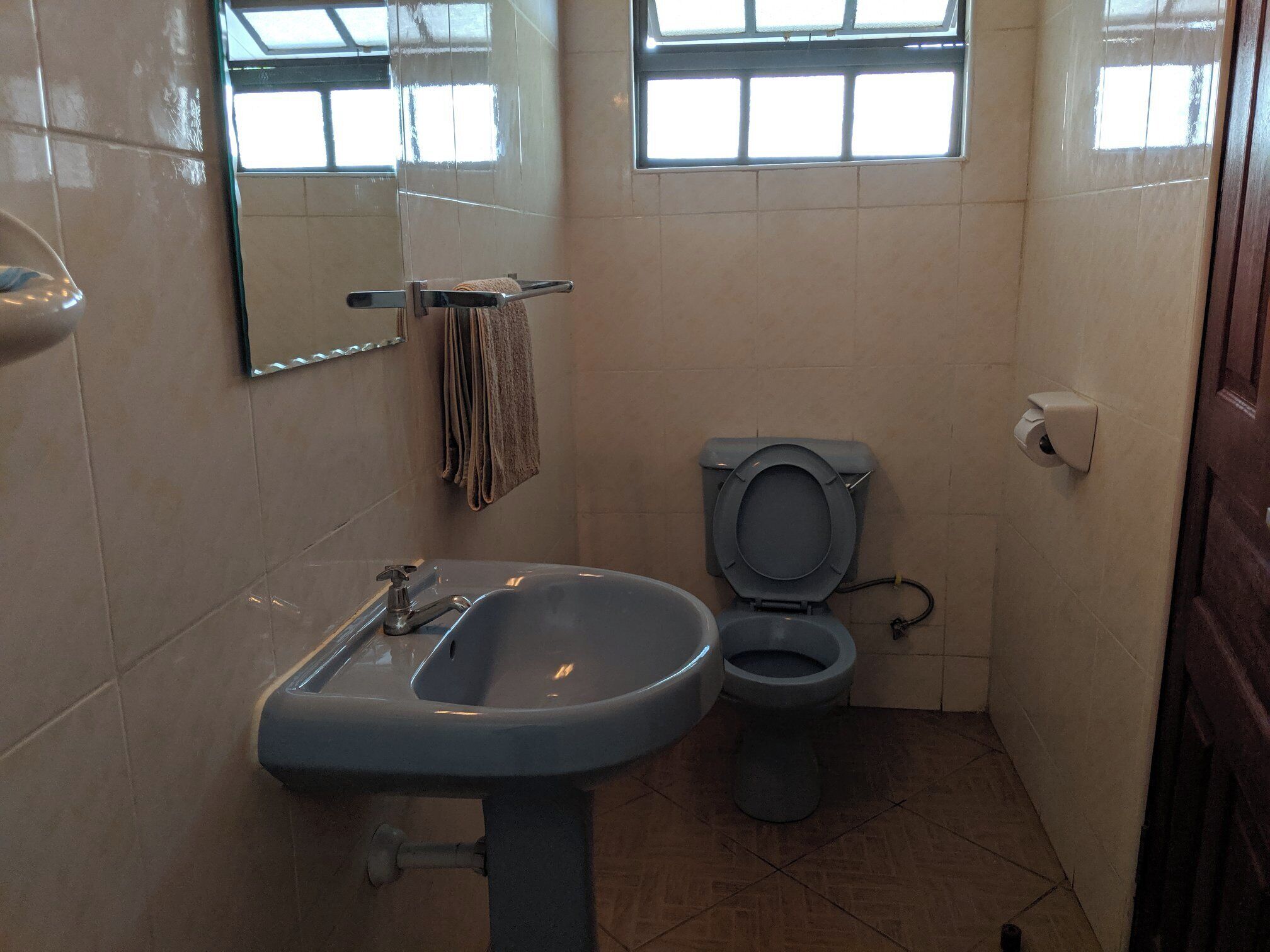 A bathroom with a sink, toilet, and a towel rack.